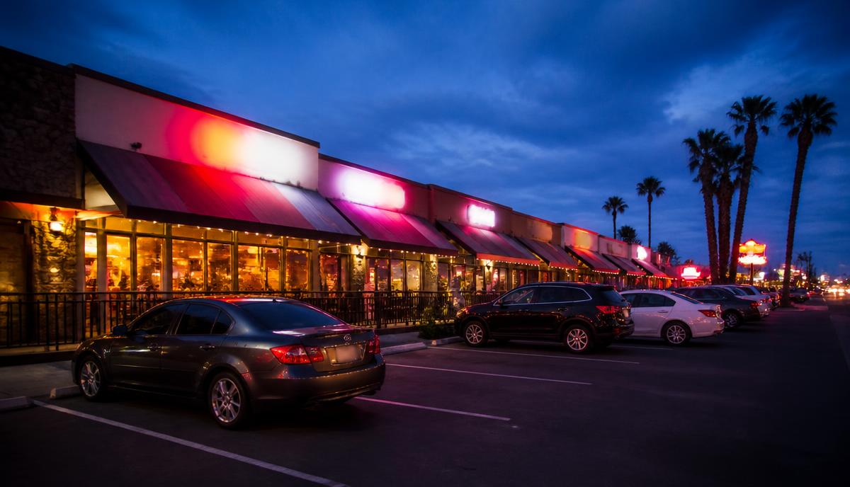 Asian restaurant plaza in San Diego's Convoy District glowing at dusk with cars parked out front