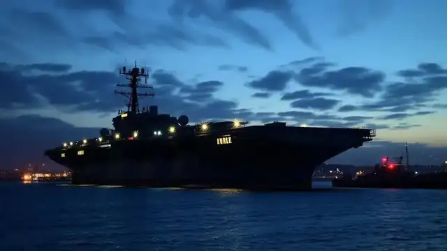USS Midway aircraft carrier at dusk in San Diego harbor with eerie atmospheric lighting