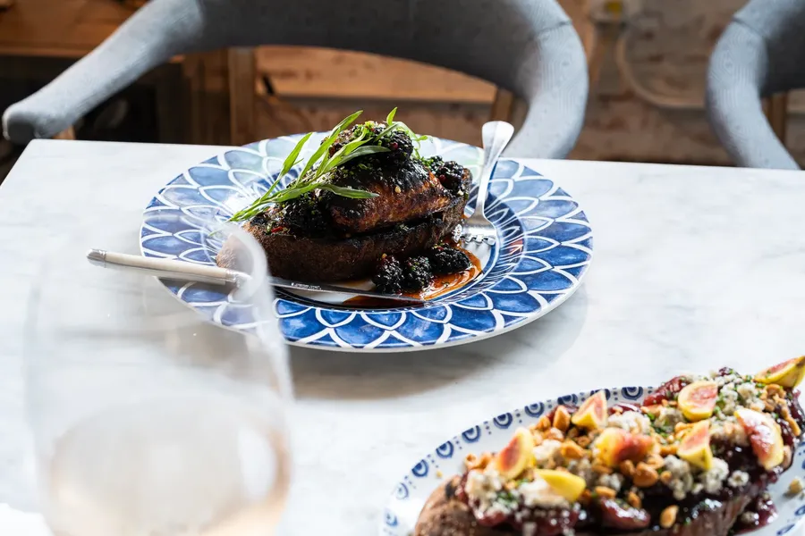 Wood-fired dishes plated at Herb & Wood in Little Italy, San Diego