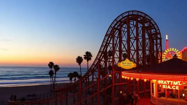 Wooden roller coaster on the Mission Beach boardwalk in San Diego at sunset with the ocean behind it