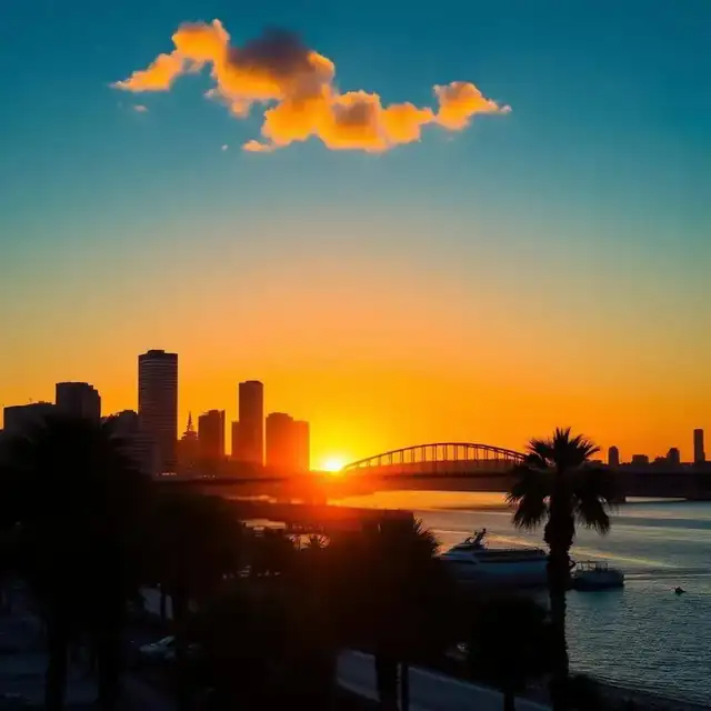 San Diego skyline at sunset with the Coronado Bay Bridge and palm trees