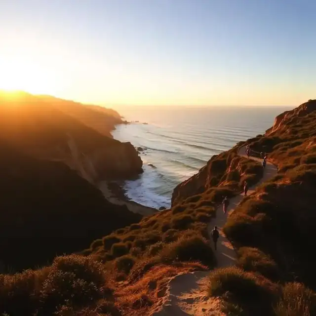 Hikers on a Torrey Pines coastal trail at sunset above the Pacific Ocean