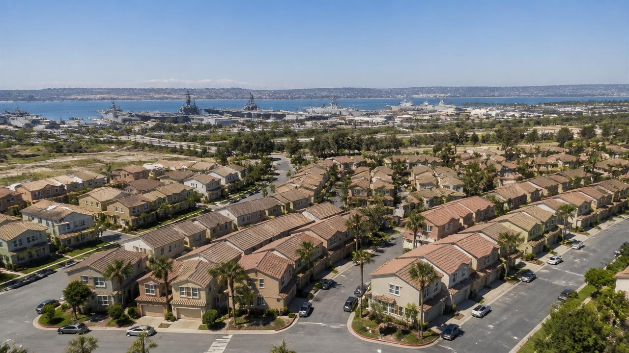 Aerial view of San Diego military housing neighborhood with naval base waterfront in the distance