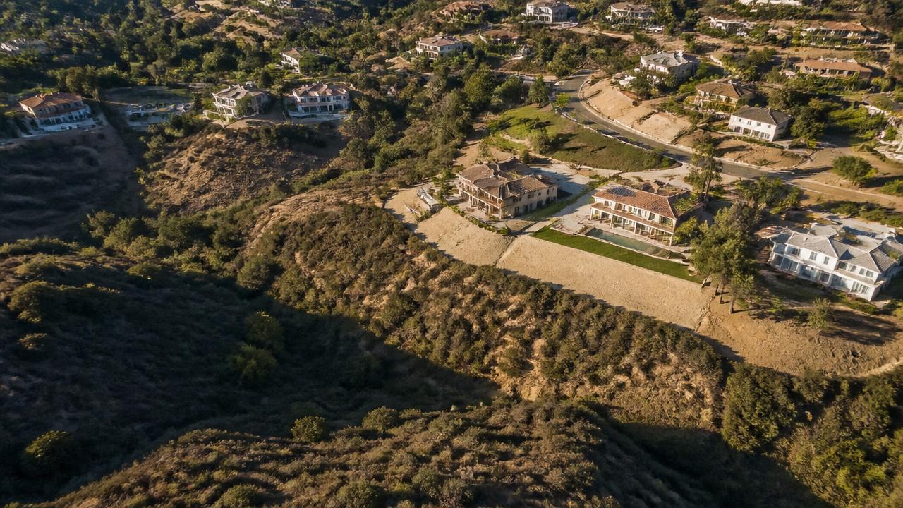Aerial view of a San Diego hillside neighborhood with homes bordering dry chaparral canyon brush