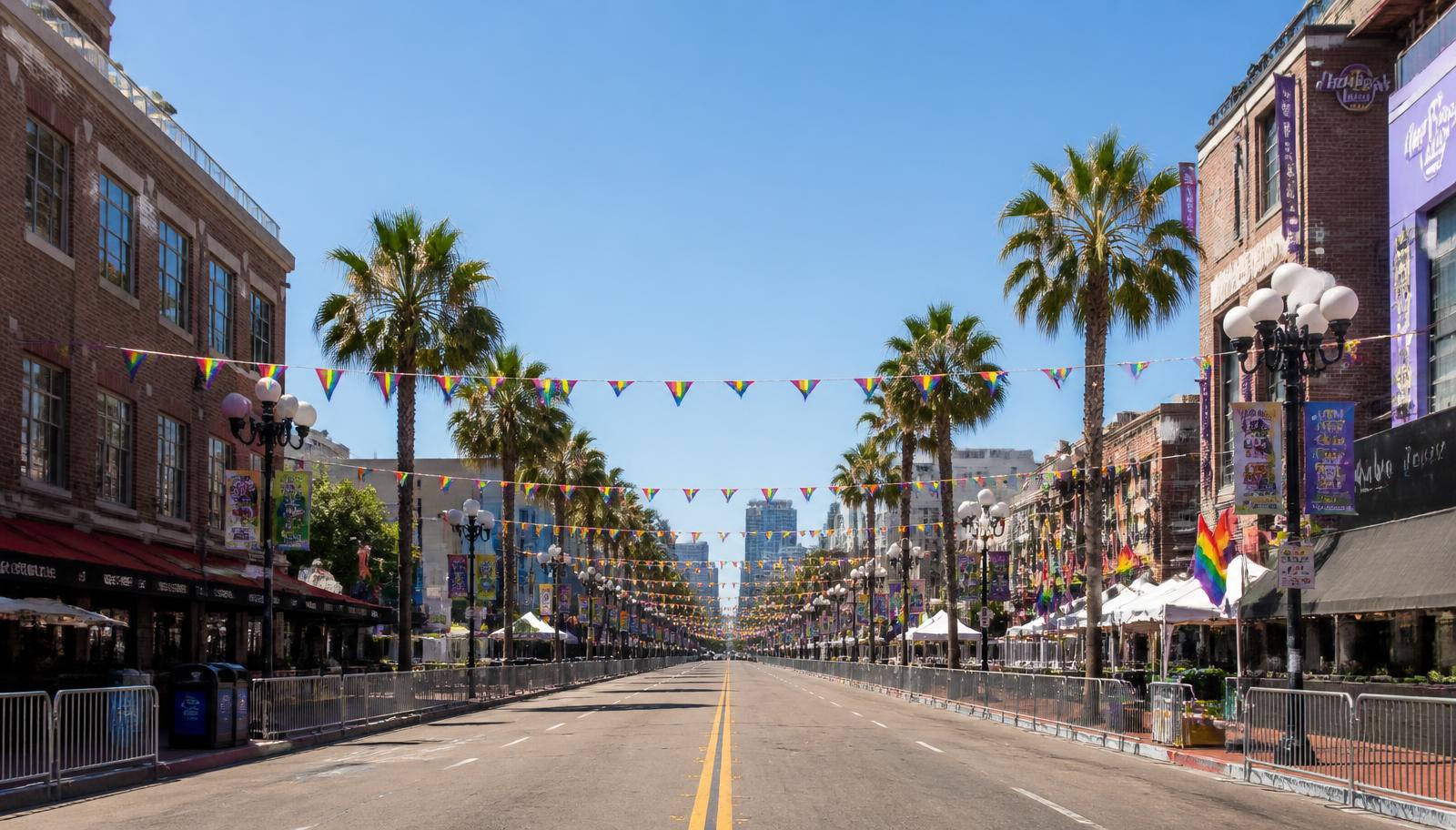 Sunny San Diego street lined with palm trees and rainbow pride bunting with barricades set up before a festival